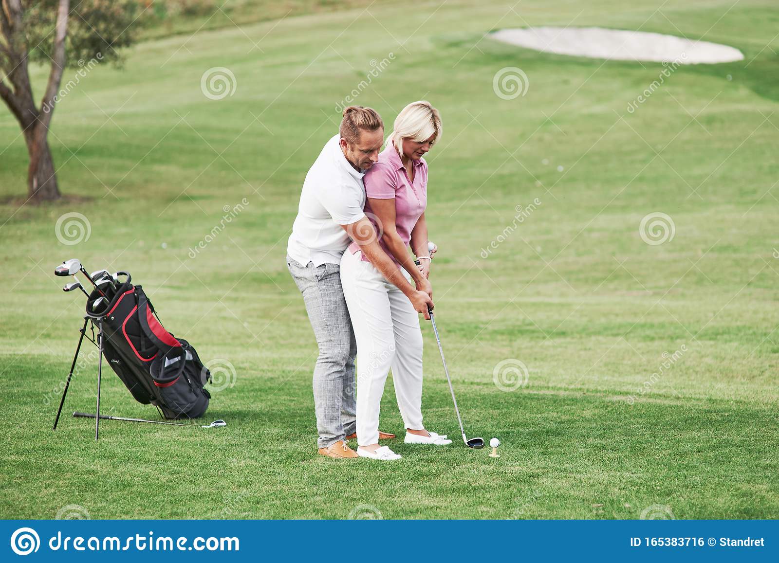 Учит играть в гольф. Мужчина женщина гольф. Мужчина и женщина играют в гольф. Гольф мужчина учит. Женщина играет в гольф.